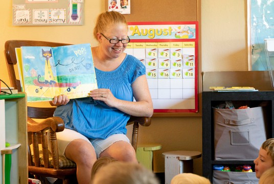 Teacher reading a book to students