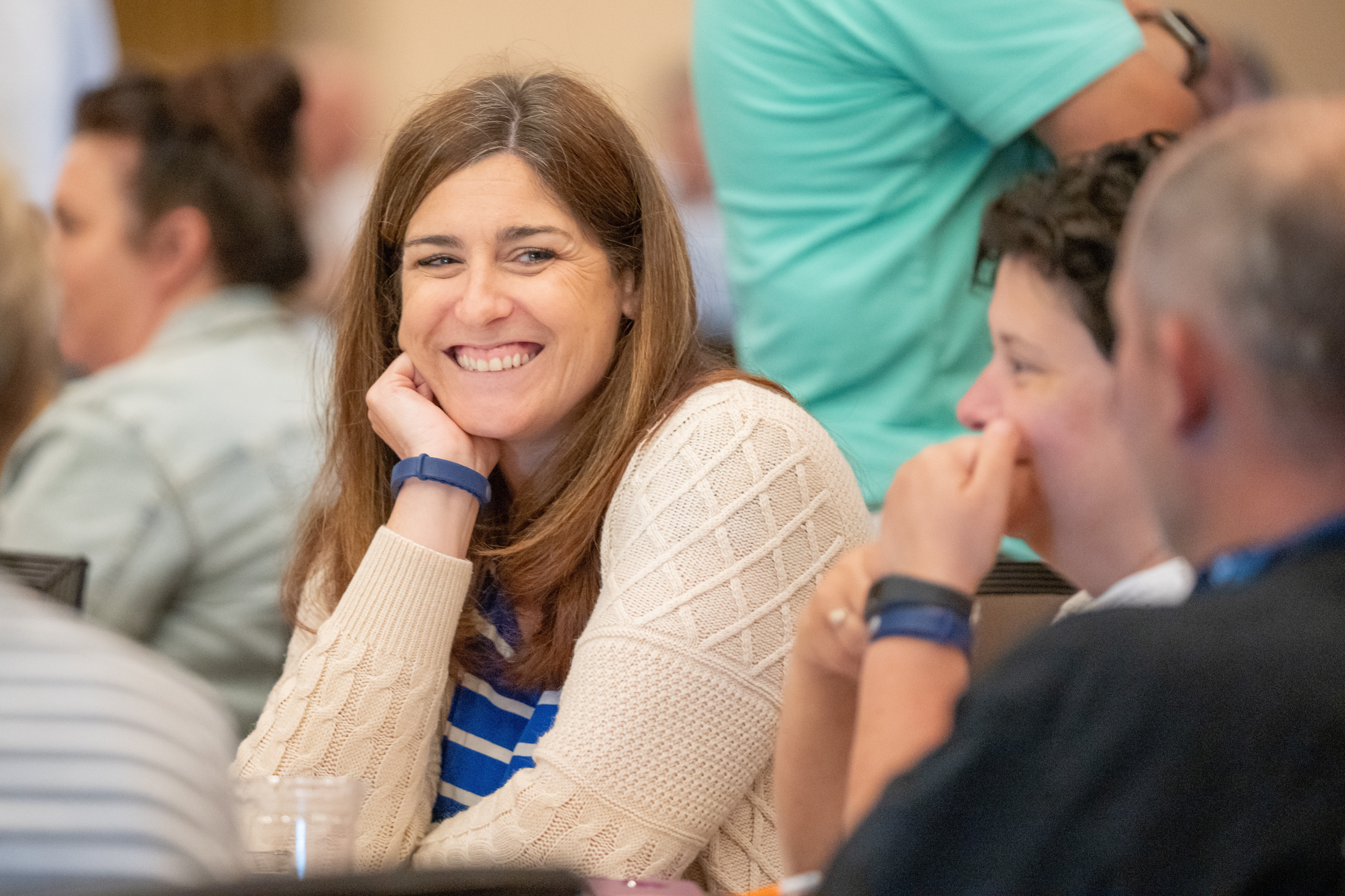 A school leader smiling at colleagues 